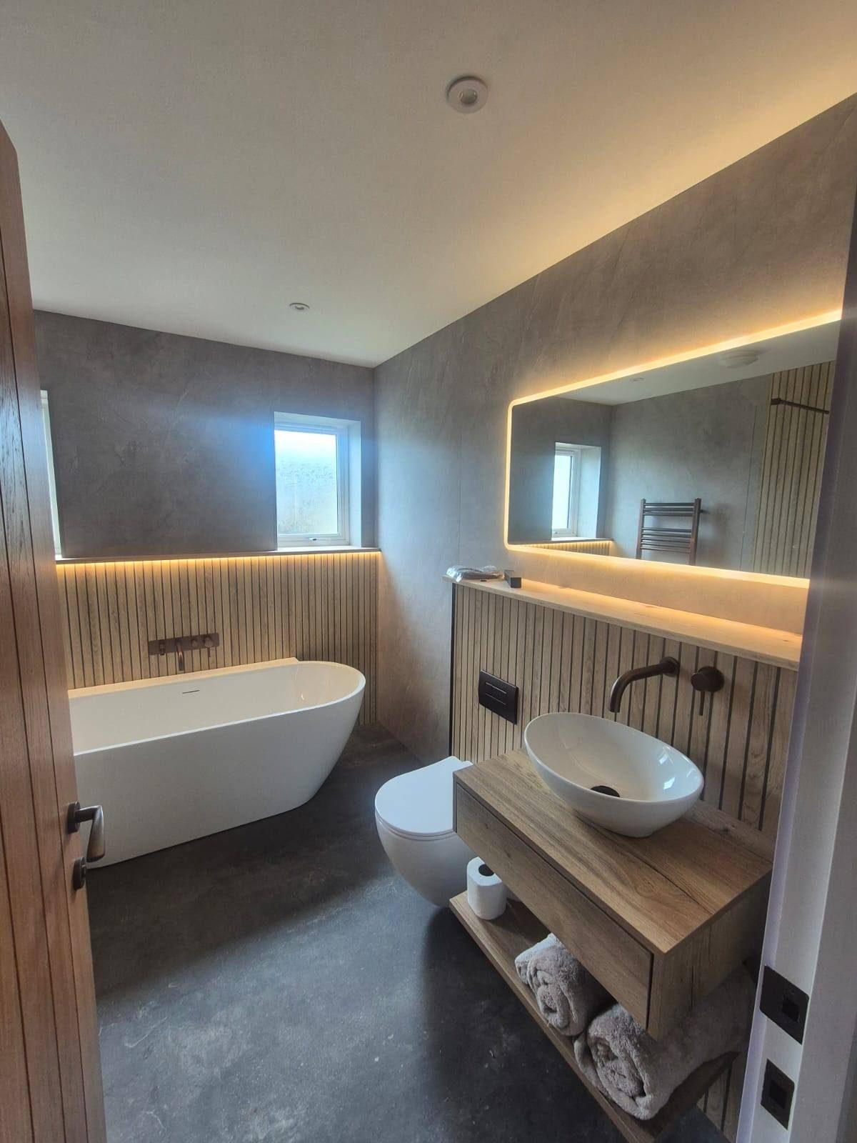 Premium bathroom renovation with freestanding bath and microcement walls