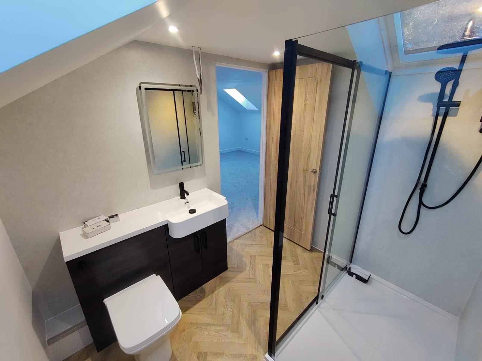 En-suite shower room with black-framed enclosure and herringbone floor