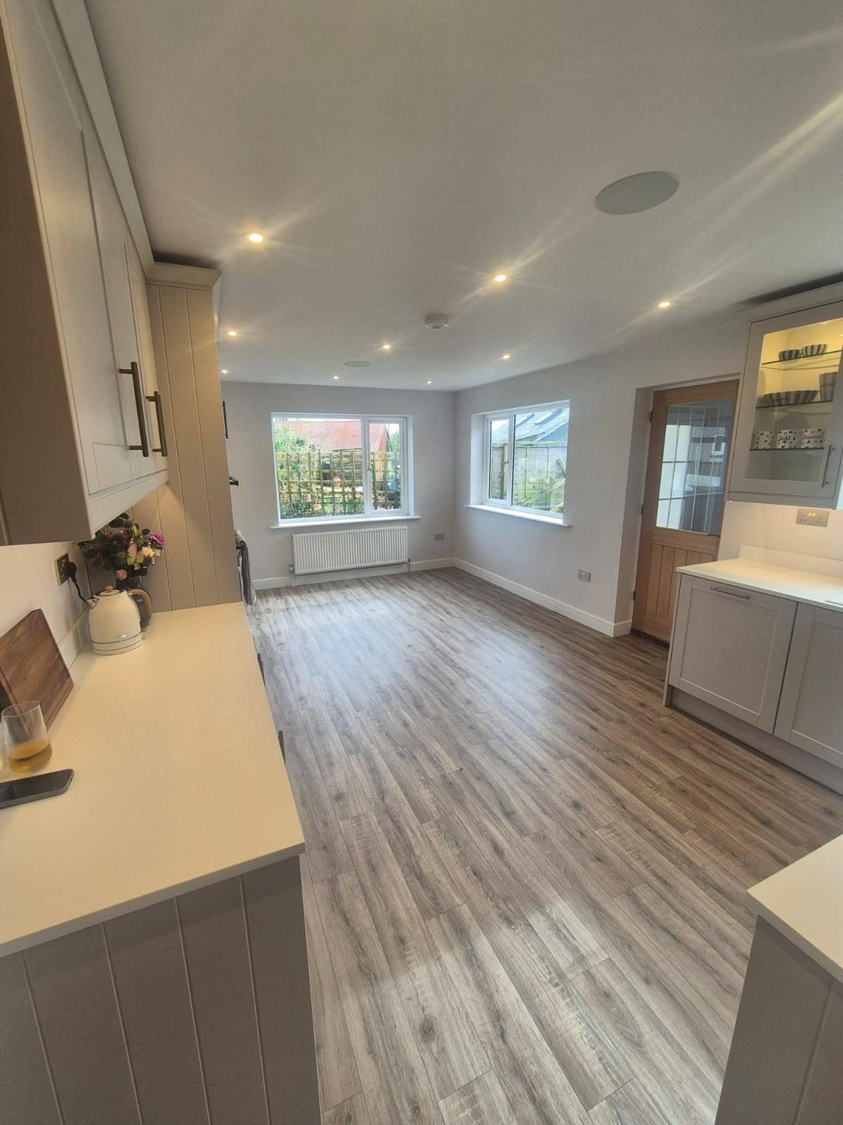 Open-plan kitchen-diner extension with grey wood flooring