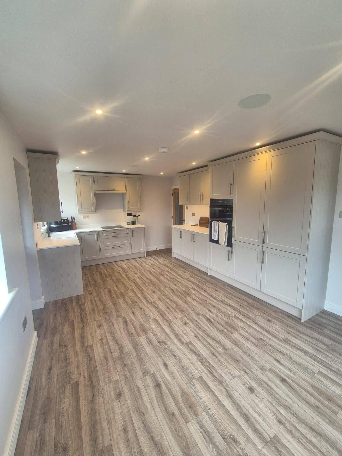 Large open-plan cream kitchen with integrated appliances