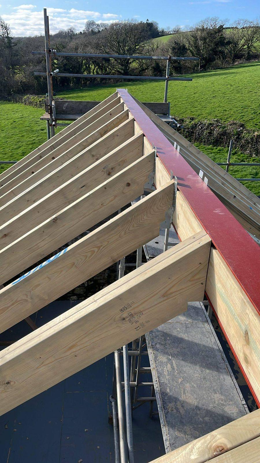 New roof timbers and ridge over open countryside