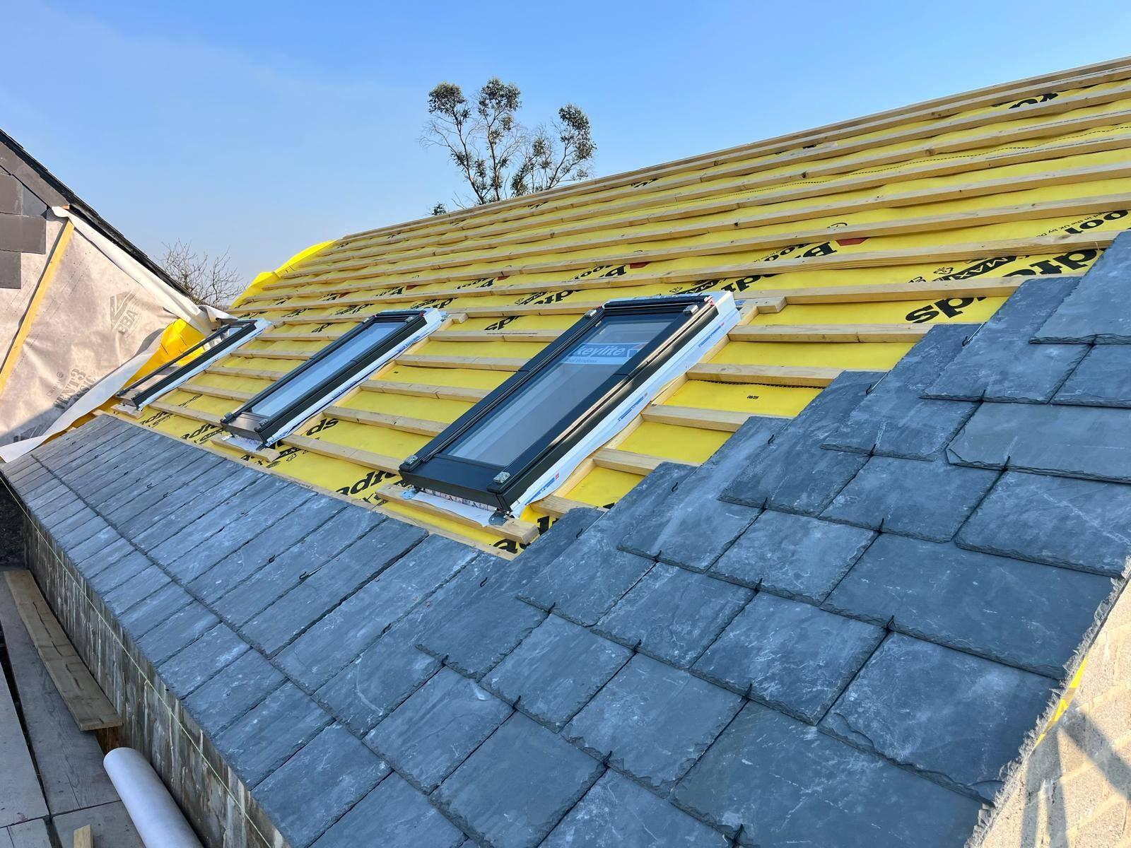 Slate roof with new conservation rooflights being installed