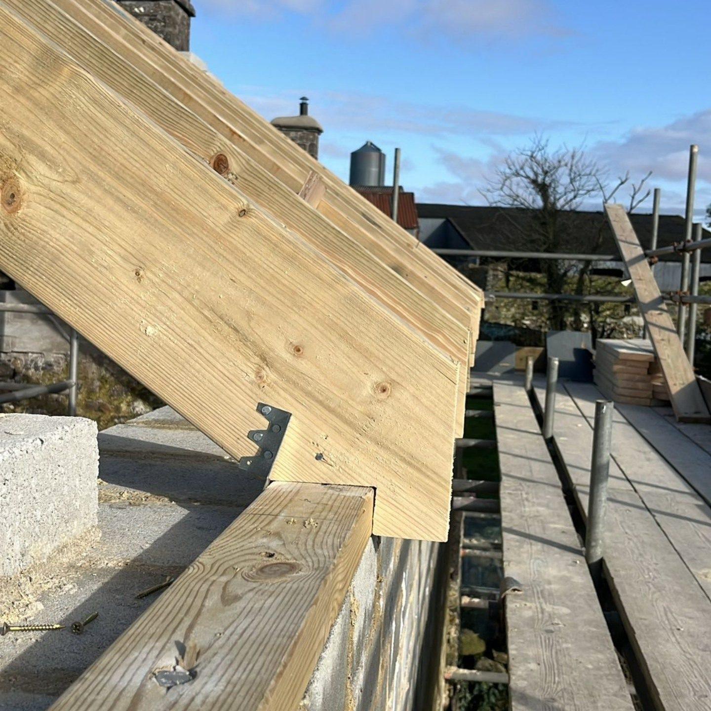 New timber roof rafter on a wall plate against blue sky