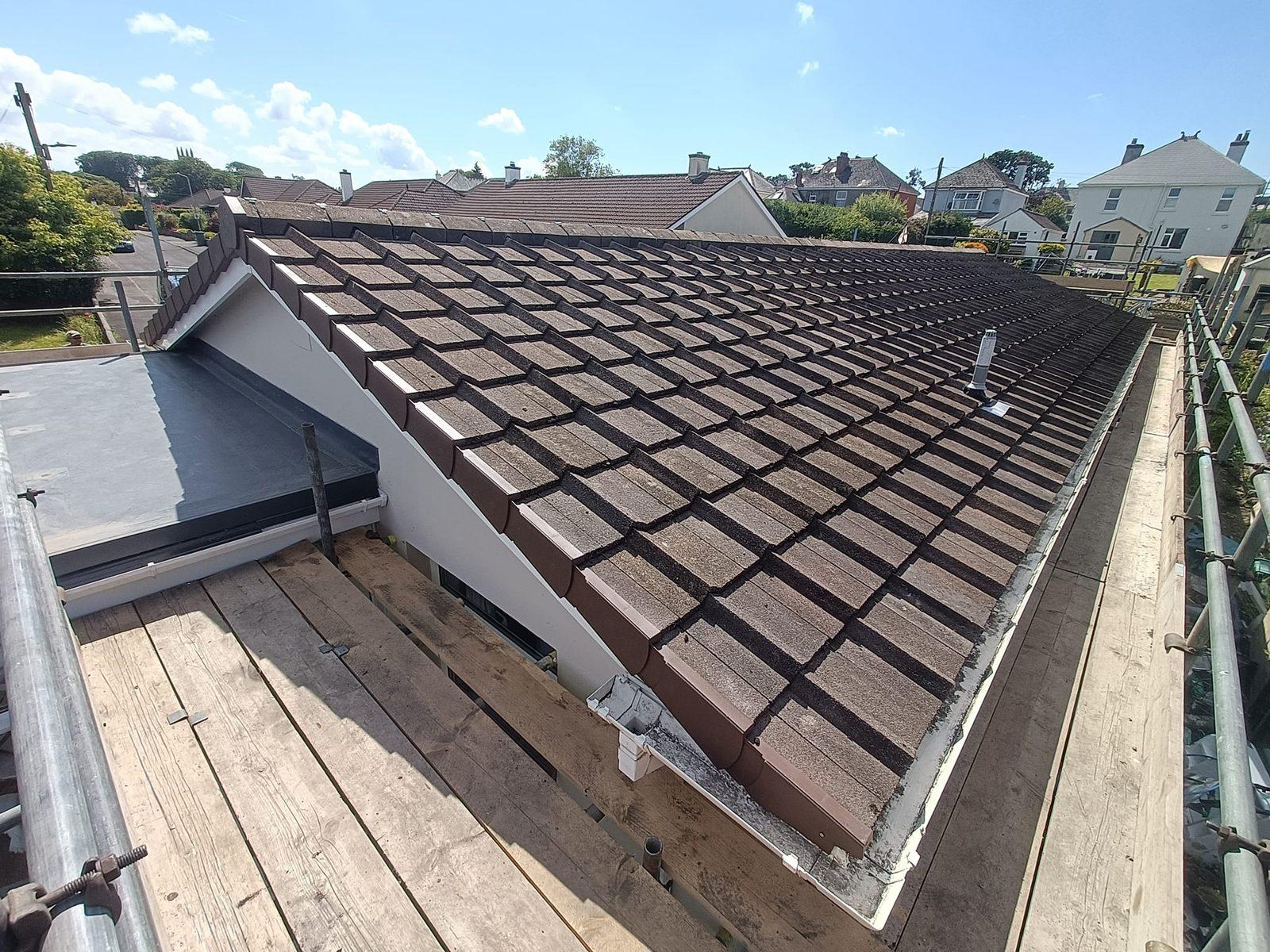 Freshly laid tiled roof viewed from scaffolding — completed roof replacement
